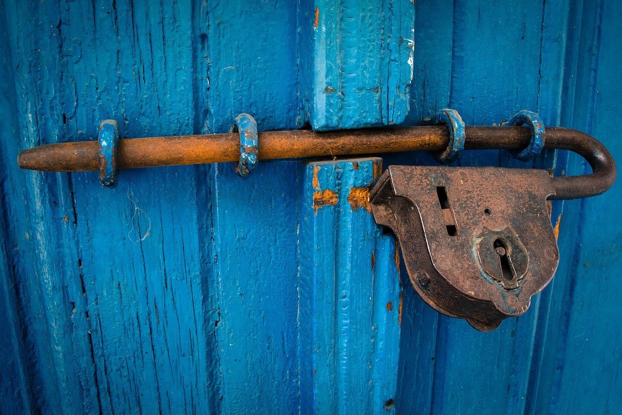 Digital padlock icon over cryptocurrency symbols, representing security